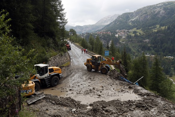 Worker use diggers to clean the road of the nineteenth stage of the Tour de France cycling race over 126,5 kilometers (78,60 miles) with start in Saint Jean De Maurienne and finish in Tignes, France,  ...