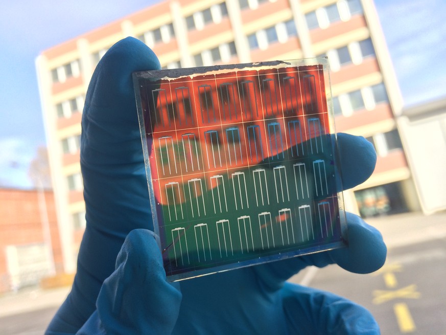 Ein Forscher zeigt, wie transparent die neue, an der Empa entwickelte Perowskit-Zelle ist.&nbsp;
