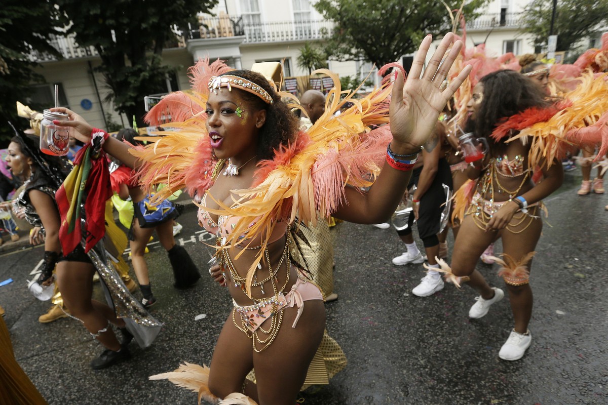 FILE - In this Monday, Aug. 31, 2015 file photo, a costumed reveller performs in the Notting Hill Carnival in London. London's Notting Hill Carnival traces its roots to the emancipation of Black  ...