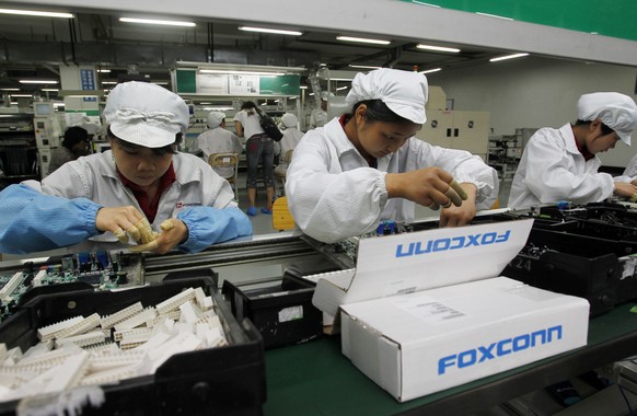 FILE - In this May 26, 2010 file photo, staff members work on the production line at the Foxconn complex in the southern Chinese city of Shenzhen, southern China. Wisconsin Gov. Scott Walker says Pres ...