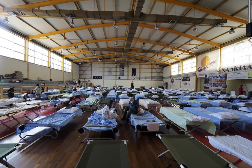 People who fled their homes during wildfires are accommodated at an indoor hall in Chalkida the capital of Evia island, about 81 kilometers (50 miles) north of Athens, Greece, Saturday, Aug. 7, 2021. ...