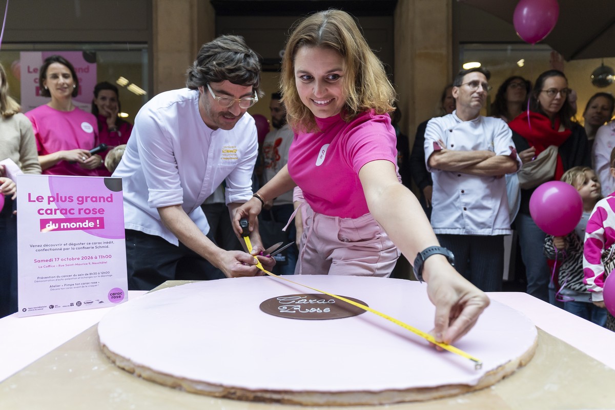 Sebastien Hegetschweiler, droite, de la Confiserie Schmid et Melanie Tanner, gauche, Fondatrice de l'association Le Carac Rose mesurent le carac rose geant lors de la presentation du plus grand C ...