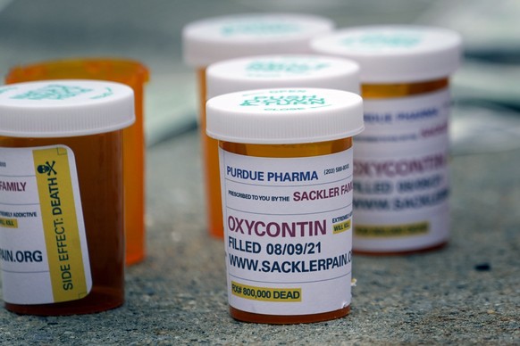 FILE - Fake pill bottles with messages about Purdue Pharma are displayed during a protest outside the courthouse where the bankruptcy of the company is taking place in White Plains, N.Y., Monday, Aug. ...