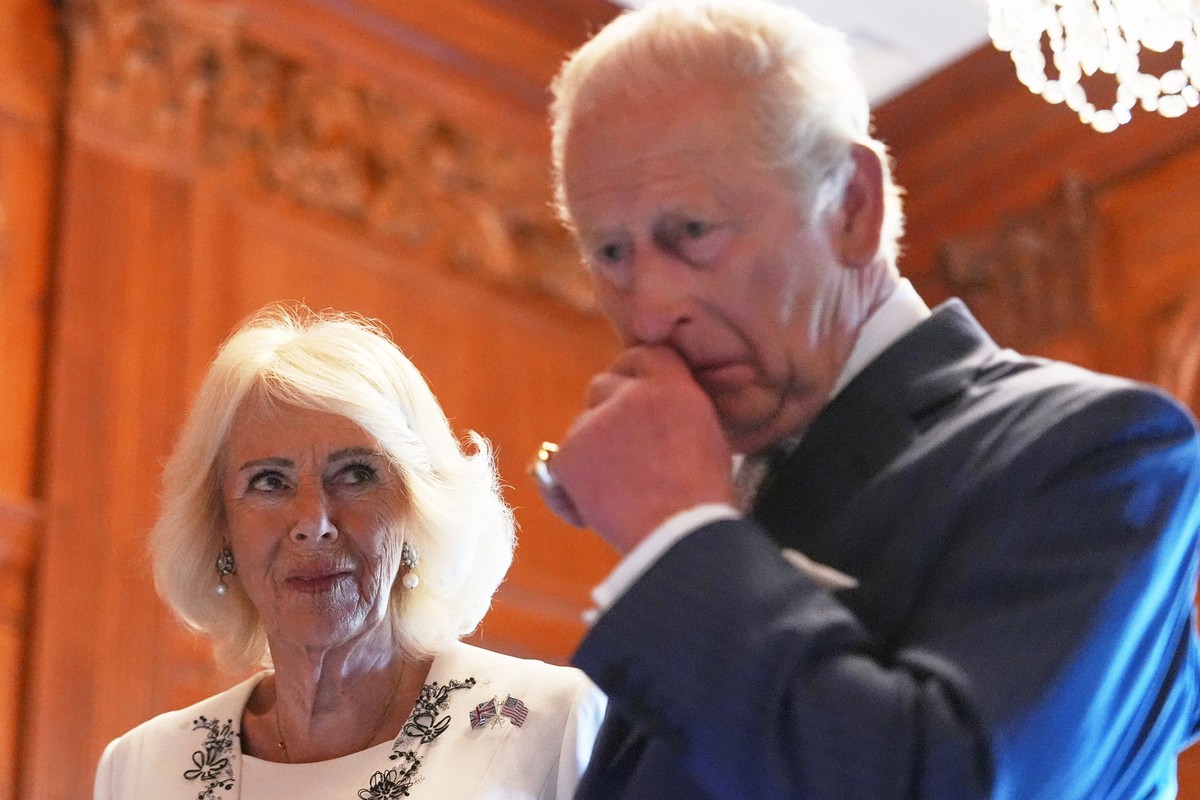 Queen Camilla and King Charles III look over items to be placed in a time capsule in honor of the United States' 250th anniversary in the Ambassador's Library room of the British Embassy, Mo ...