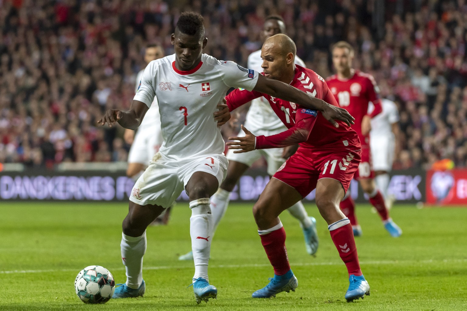 Switzerland&#039;s Breel Embolo, left, fights for the ball against Denmark&#039;s Martin Braithwaite, right, during the UEFA Euro 2020 qualifying Group D soccer match between Denmark and Switzerland a ...