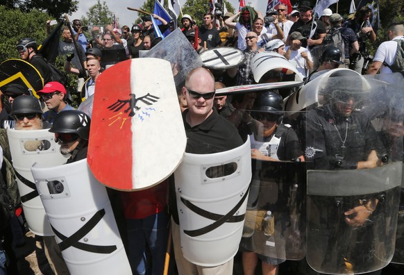 FILE - In this Aug. 12, 2017, file photo, white nationalist demonstrators use shields as they guard the entrance to Lee Park in Charlottesville, Va. Anxious to avoid the mayhem that has erupted at gat ...