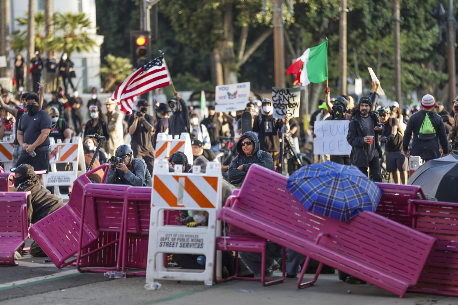 epa12165646 Activists hide behind a makeshift barricade during protests sparked by immigration raids in Los Angeles, California, USA, 08 June 2025. US President Donald Trump has deployed 2,000 Nationa ...