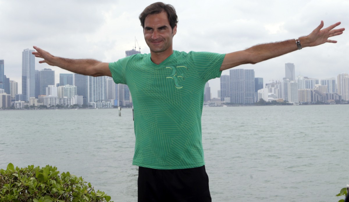 Roger Federer, of Switzerland, poses for a photograph in front of the Miami skyline after defeating Rafael Nadal in the men's singles final at the Miami Open tennis tournament, Sunday, April 2, 2 ...