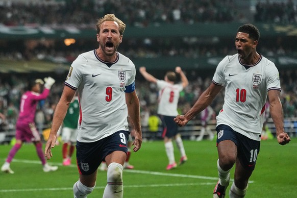 England's Harry Kane (9) celebrates with Jude Bellingham (10) after scoring his side's third goal through penalty kick during the World Cup round of 16 soccer match between Mexico and Englan ...