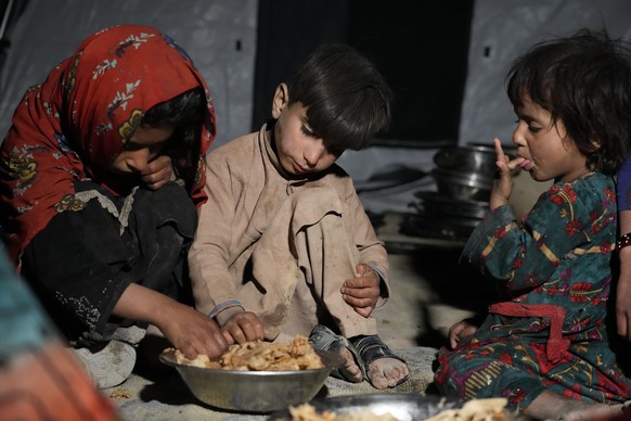 Afghan children eat in a makeshift shelter after an earthquake in Gayan district in Paktika province, Afghanistan, Saturday, June 25, 2022. A powerful earthquake struck a rugged, mountainous region of ...