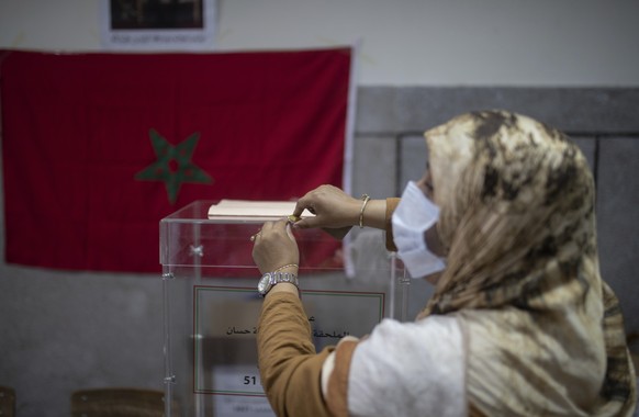 Election officials wearing face masks wait for voters inside a polling station, in Rabat, Morocco, Wednesday, Sept. 8, 2021. Moroccans are choosing a new parliament and new local leaders in elections  ...