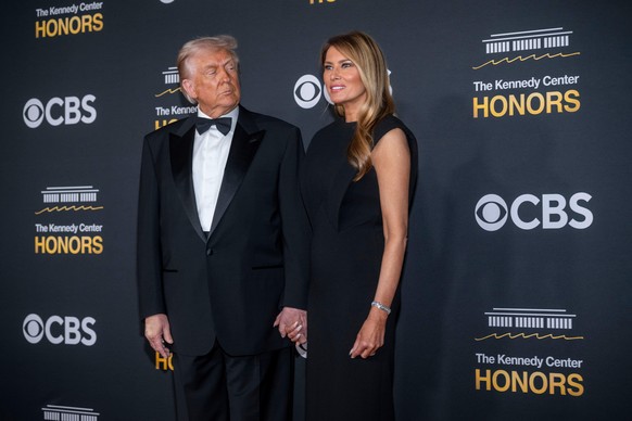 President Donald Trump looks towards First Lady Melania Trump as she answers questions on the red carpet for the 48th Kennedy Center Honors at the Kennedy Center for the Performing Arts, Sunday, Dec.  ...