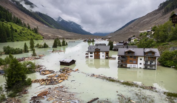 epa12156893 An aerial view shows water from the river Lonza flowing over mud and stones, after the formation of a lake on the last houses of the village of Blatten, after a massive avalanche, triggere ...