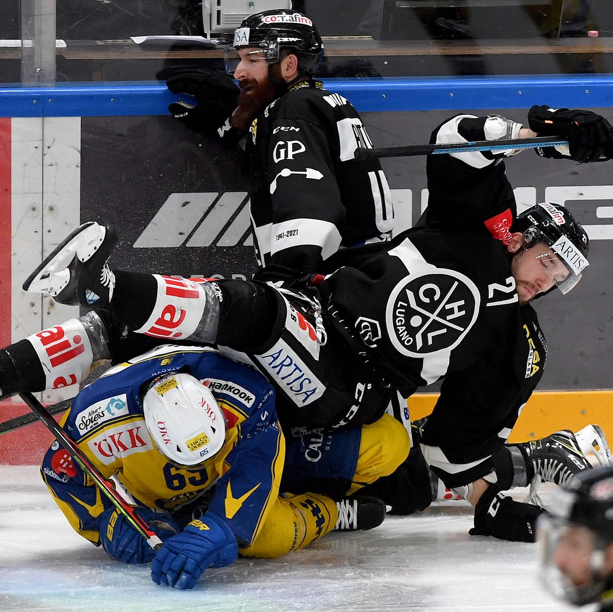 From left Davos ?s player Marc Wieser, Lugano's player Eliot Antonietti and Lugano's player Tim Traber, during the preliminary round game of National League A (NLA) Swiss Championship 2020/2 ...