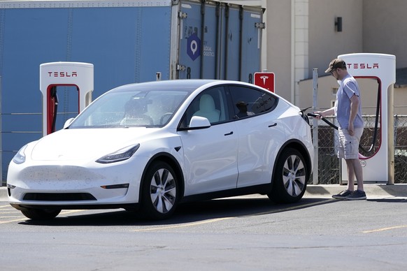 A Tesla owner charges his vehicle at a charging station in Topeka, Kan., Monday, April 5, 2021. The president and the auto industry maintain the nation is on the cusp of a gigantic shift to electric v ...