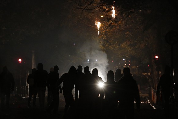 Protesters are silhouetted by the lights of a water canon during riots in Athens neighborhood of Exarchia, a haven for extreme leftists and anarchists, on Saturday, Dec. 6, 2014. A march through centr ...