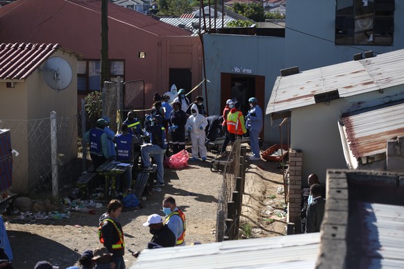 epa10034985 South African Police Forces (SAPS) and forensics experts work at the scene where an estimated 20 young people died in Enyobeni Tavern in East London, South Africa, 26 June 2022. The cause  ...