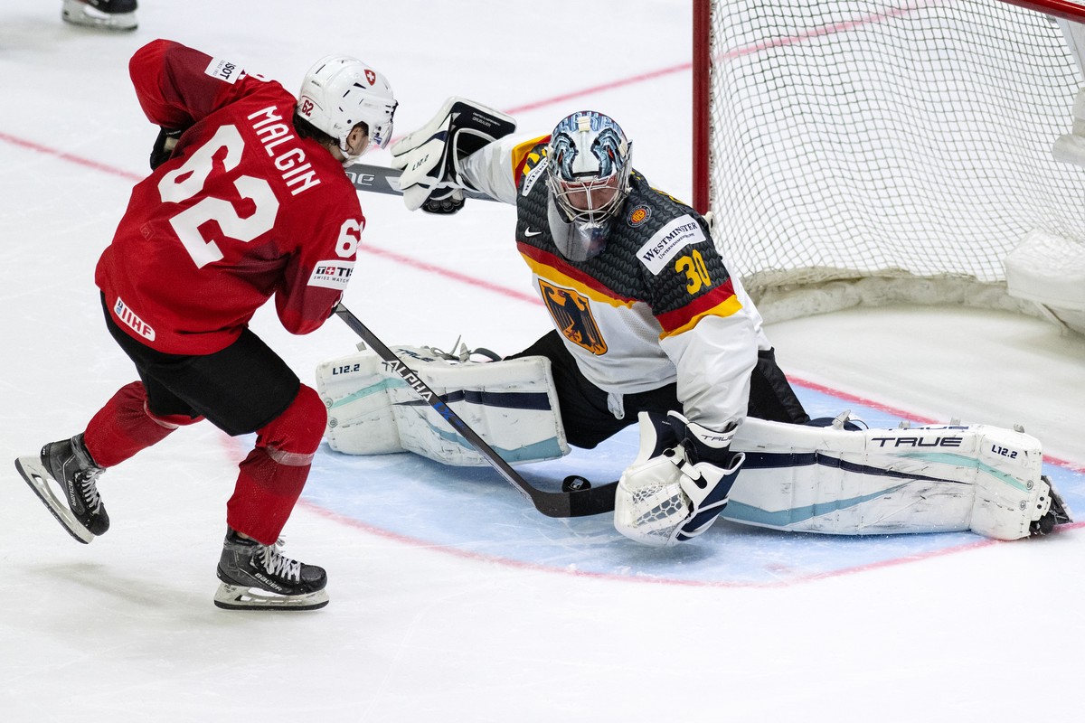 Switzerland's Denis Malgin, left, in action against Germany's goalkeeper Philipp Grubauer during the Ice Hockey World Championship group A preliminary round match between Switzerland and Ger ...