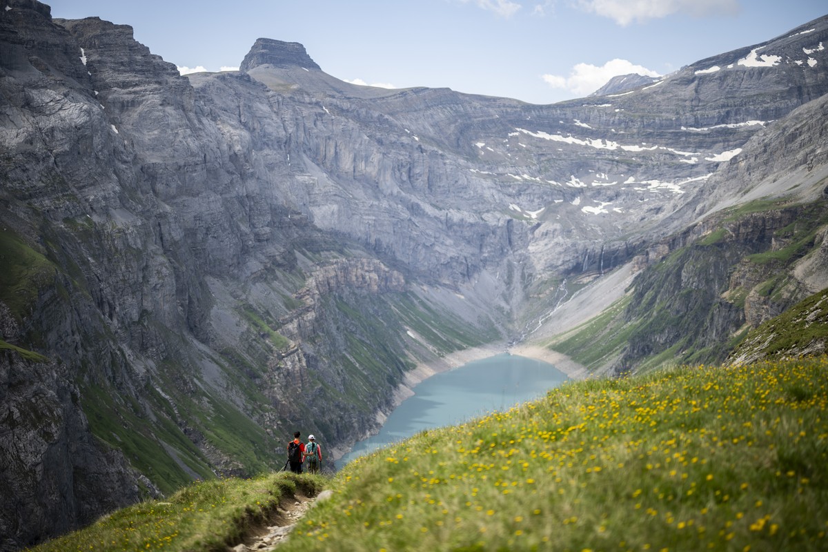Zwei Wanderer geniessen die Aussicht auf den Limmerensee, einen Speichersee, aufgenommen am Montag, 10. Juli 2023, in Linthal. (KEYSTONE/Gian Ehrenzeller)