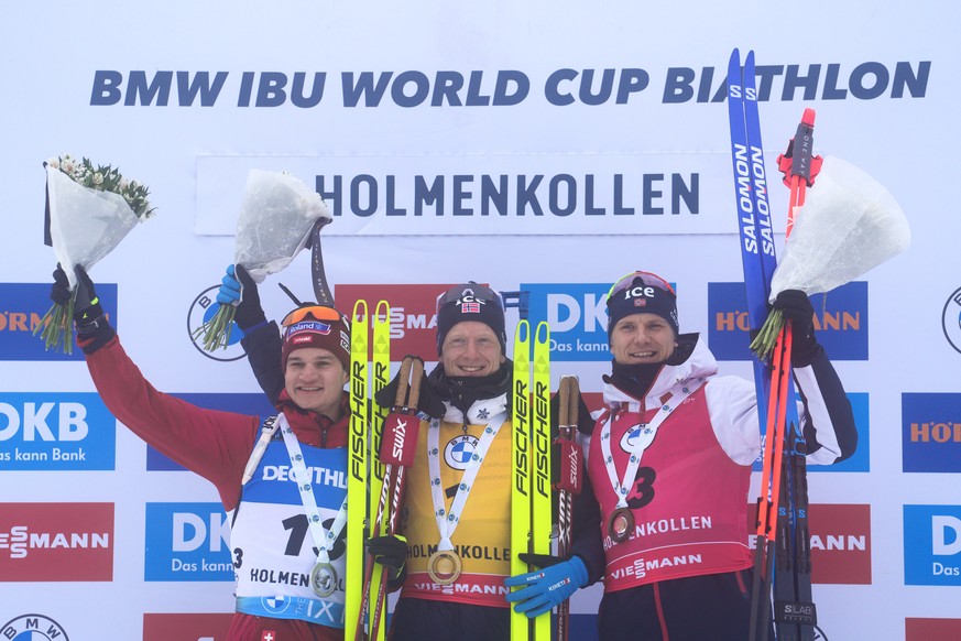 epa10531813 (L-R) Second placed Niklas Hartweg of Switzerland, winner Johannes Thingnes Bo of Norway and third placed Vetle Sjaastad Christensen of Norway celebrate on the podium after the men's ...
