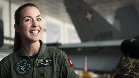 Fanny Chollet, the first female fighter pilot of the Swiss air force smiles in front of a F/A-18 Hornet fighter jet during a press conference at the Swiss army airbase in Payerne, Tuesday, February 19 ...