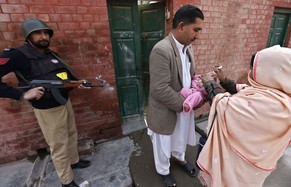 Pakistanische Sicherheitskräfte begleiten Impfhelfer auf ihrem Einsatz.