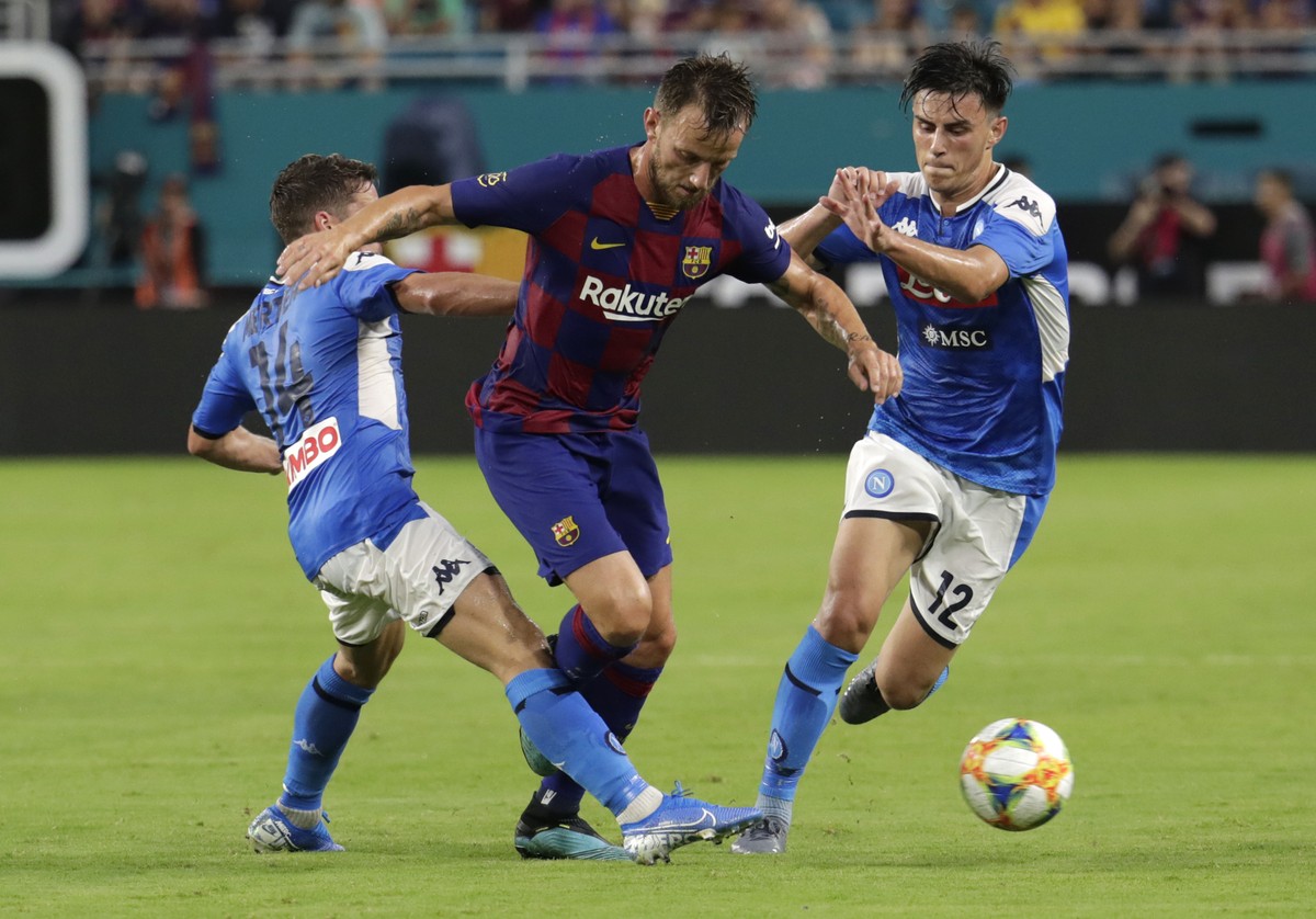 Barcelona's Ivan Rakitic, center, goes for the ball as Napoli's Dries Mertens (14) and Nikita Contini (12) defend during the first half of a soccer match Wednesday, Aug. 7, 2019, in Miami Ga ...