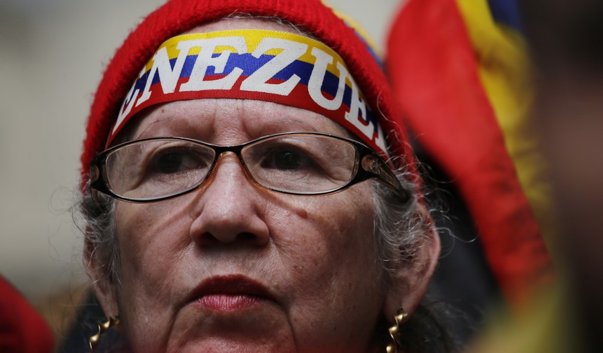 A woman waits for the arrival of Juan Guaido at a public plaza where he is expected to speak in Caracas, Venezuela, Friday, Jan. 25, 2019. Guaido is an opposition leader who declared himself interim p ...