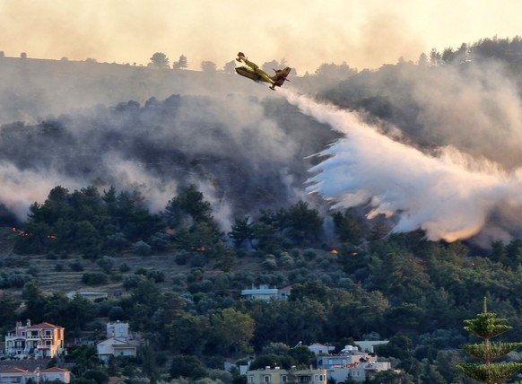 epa12191535 A Canadair plane drops water over a wildfire on Chios Island, Greece, 22 June 2025. A fire that broke out over the main town of Chios island and is now out of control has led to messages f ...