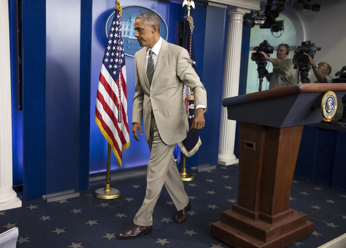 President Barack Obama leaves the James Brady Press Briefing Room of the White House in Washington, Thursday, Aug. 28, 2014, after speaking about the economy, Iraq, and Ukraine, before convening a mee ...