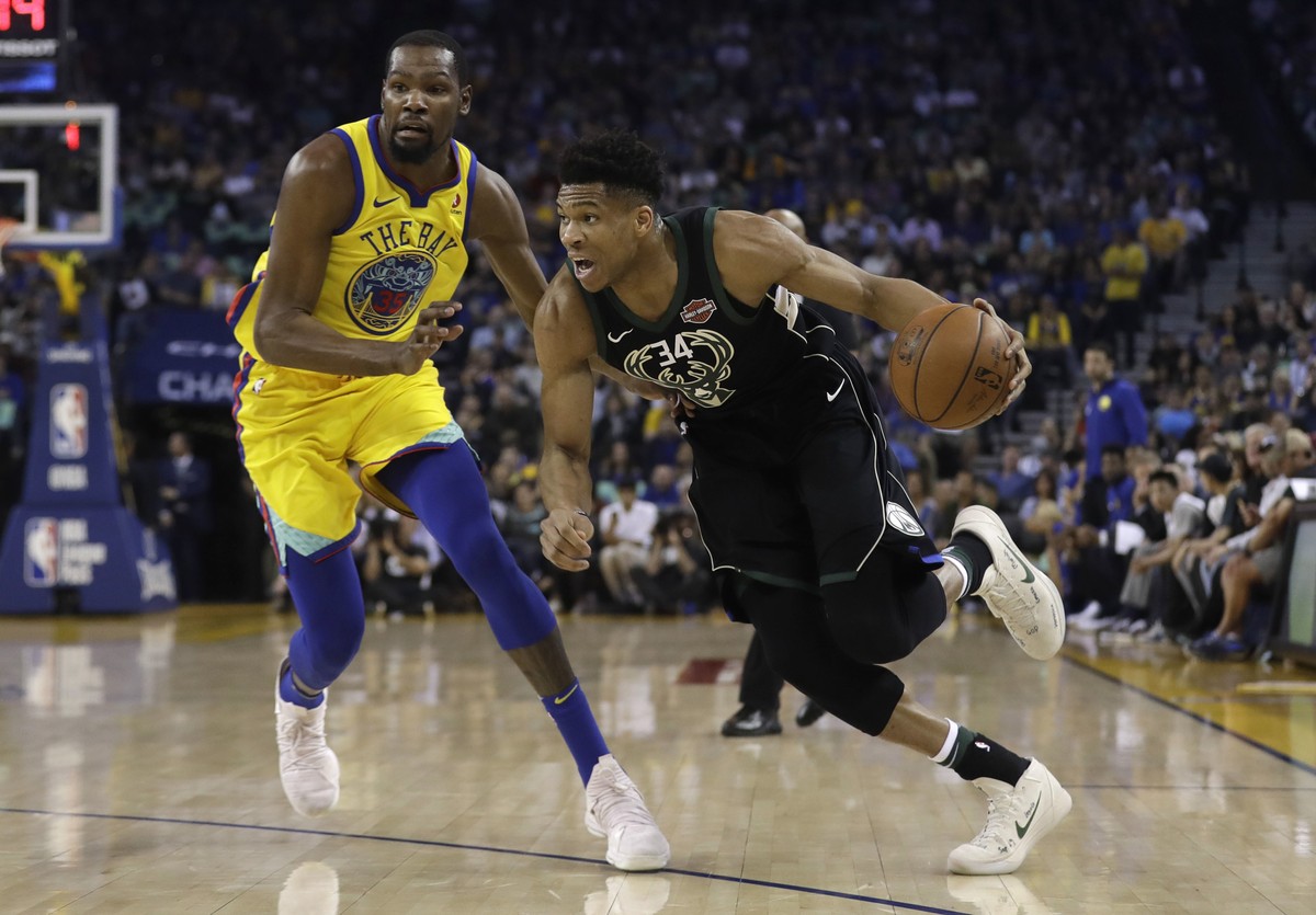Milwaukee Bucks' Giannis Antetokounmpo, right, drives past Golden State Warriors' Kevin Durant during the first half of an NBA basketball game Thursday, March 29, 2018, in Oakland, Calif. (A ...
