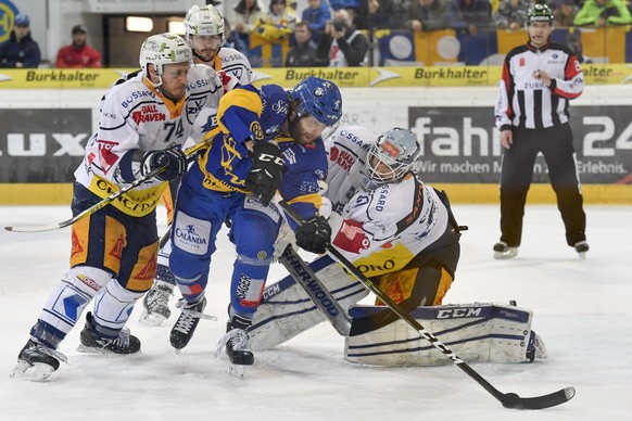 Claude-Curdin Paschoud von Davos, Mitte, gegen Johann Morant, links, und Goalie Tobias Stephan von Zug, beim zweiten Playoff-Halbfinalspiel der National League A zwischen dem HC Davos und EV Zug, am D ...