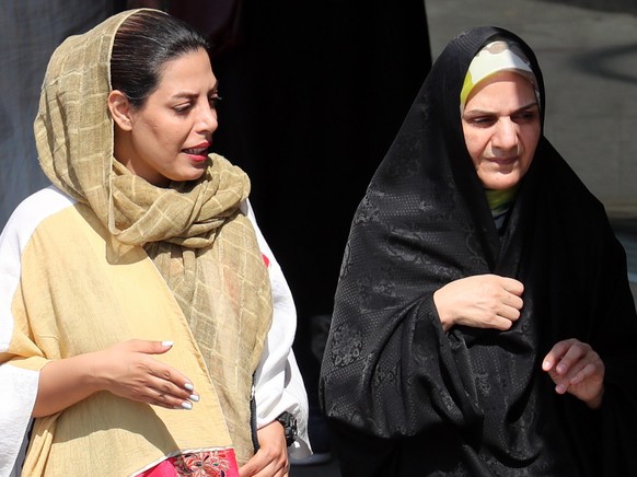 epa10193155 Iranian women walk past in a street, in Tehran, Iran, 19 September 2022. Mahsa Amini, a 22 year old girl, was detained on 13 September by the police unit responsible for enforcing Iran&#03 ...