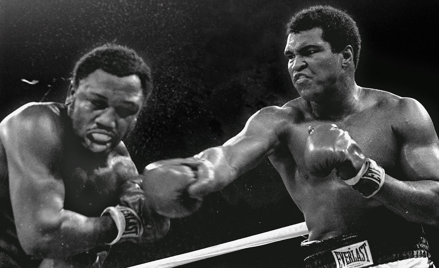 Schweiss spritzt vom Kopf des Herausforderers Joe Frazier, links, als der Schwergewichts Champion Muhammad Ali beim Titelkampf in Manila am 1. Oktober 1975 seine Rechte landen laesst. Box-Legende Muha ...