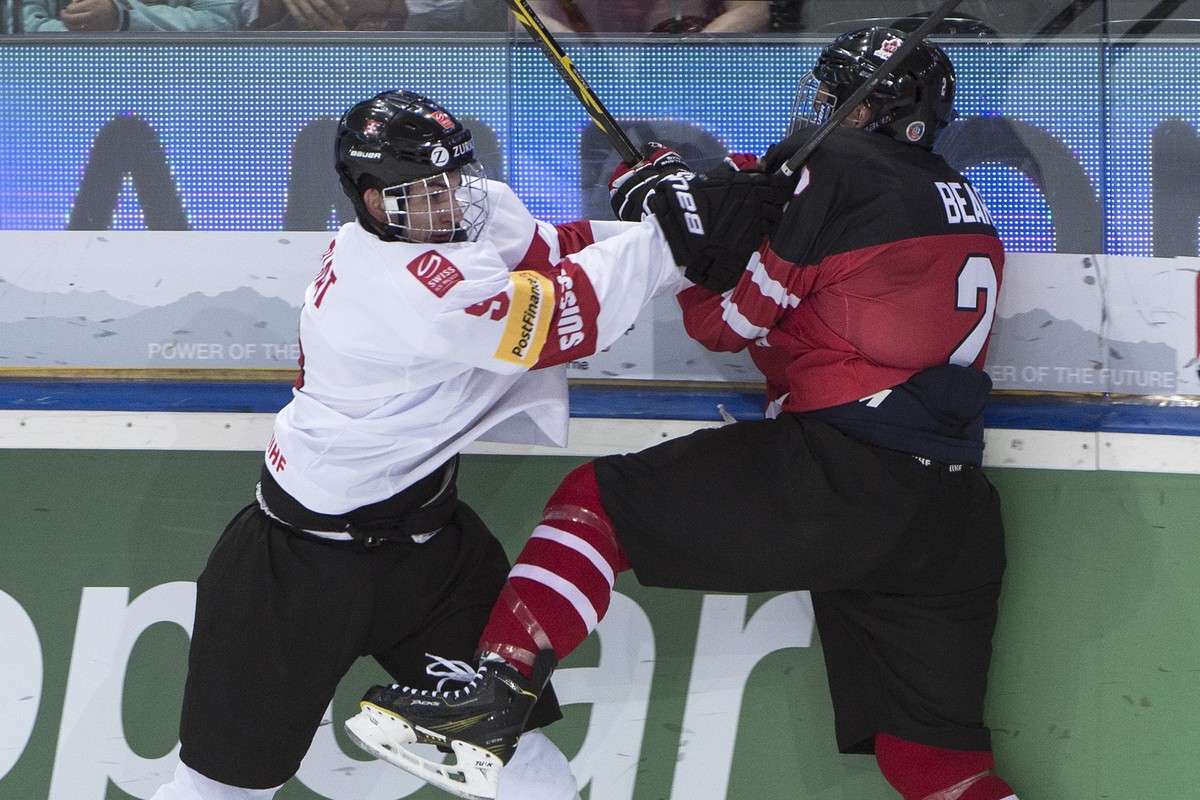 Switzerland's Damien Riat, left, and Canada's Ethan Bear, right, play for the puck during a the ice hockey U18 World Championships bronce medal game match between Switzerland and Canada, at  ...