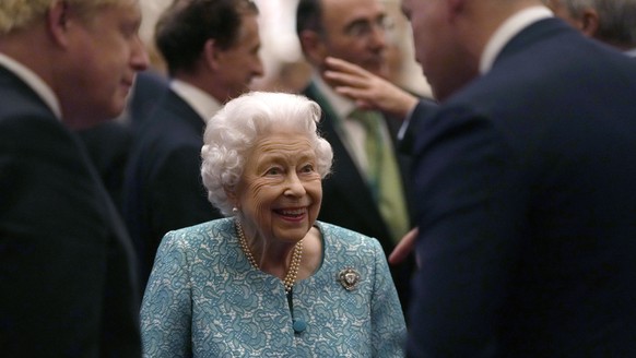 FILE - In this Tuesday, Oct. 19, 2021 file photo, Britain&#039;s Queen Elizabeth II and Prime Minister Boris Johnson, left, greet guests at a reception for the Global Investment Summit in Windsor Cast ...