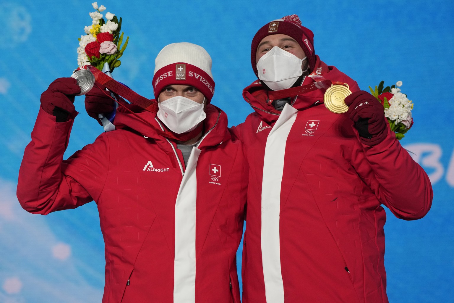 Silver medalist Switzerland&#039;s Alex Fiva, left, and Gold medalist Switzerland&#039;s Ryan Regez pose during a medal ceremony for the freestyle skiing men&#039;s cross competition at the 2022 Winte ...