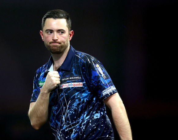 England's Luke Humphries celebrates defeating Netherlands' Kevin Doets on day 17 of the World Darts Championship at the Alexandra Palace in London, England, Tuesday, Dec. 30, 2025. (Steven P ...