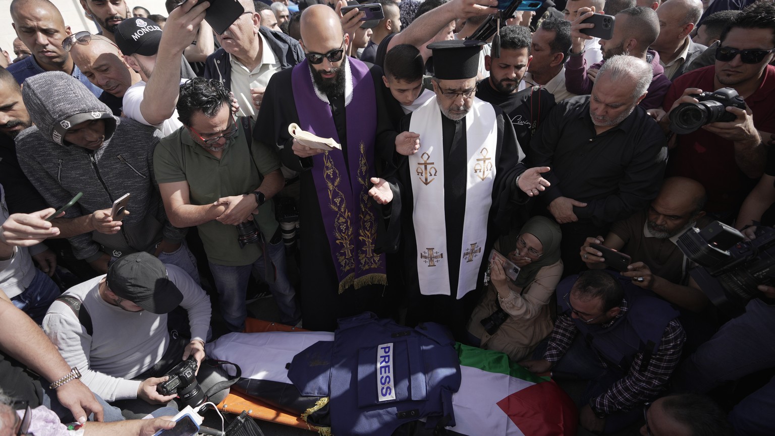 Journalists surround the body of Shireen Abu Akleh, a journalist for Al Jazeera network, into the morgue inside the Hospital in the West Bank town of Jenin, Wednesday, May 11, 2022. The well-known Pal ...