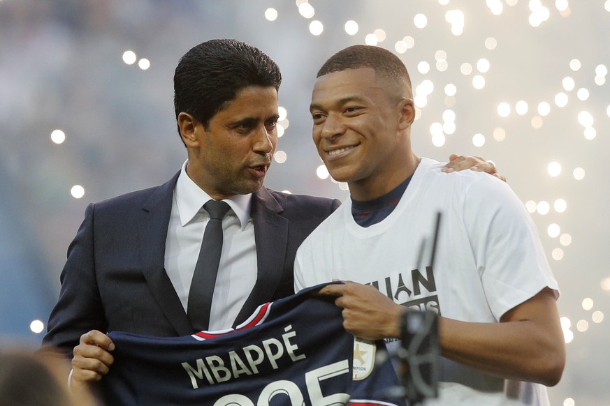 PSG President Nasser Al-Khelaifi, left, speaks to PSG&#039;s Kylian Mbappe who holds a shirt with his name and 2025 on it as it is announced he has signed a three year extension to his contract on the ...