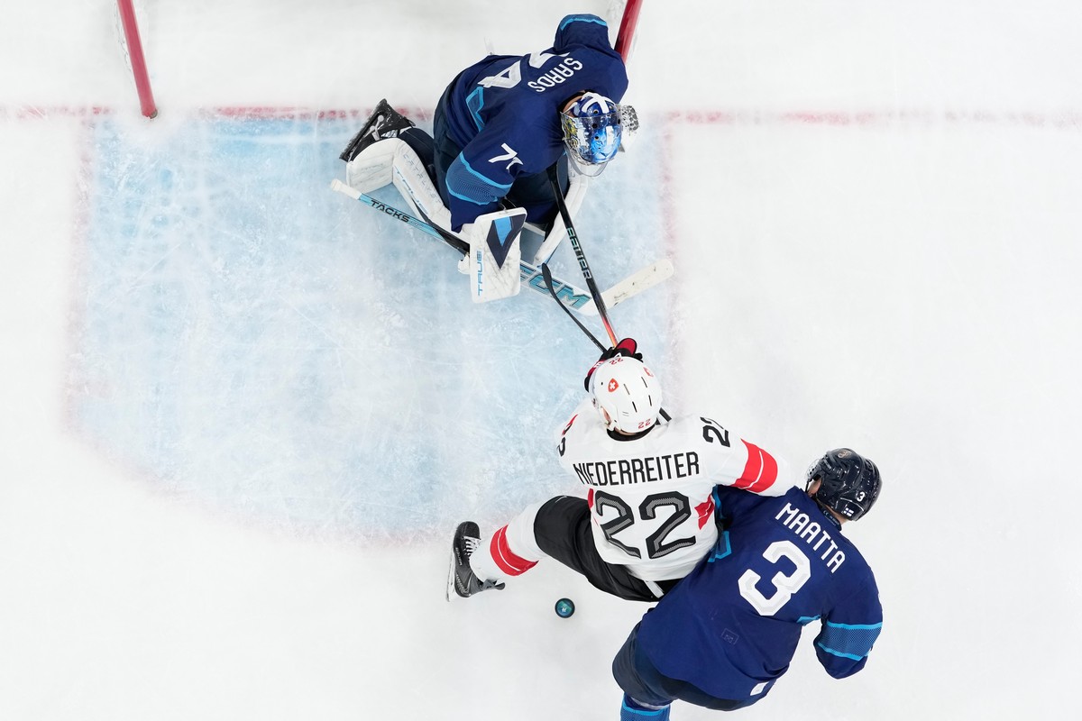 Switzerland's Nino Niederreiter (22) is challenged by Olli Maatta (3) during a men's ice hockey quarterfinal game between Finland and Switzerland at the 2026 Winter Olympics, in Milan, Italy ...