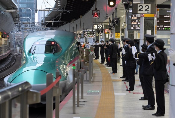 Mitarbeiter des Bahnhofs von Tokio applaudieren, während ein Tohoku-Shinkansen-Zug vom Bahnhof in Tokio abfährt, am 14. April 2022 (Symbolbild). 