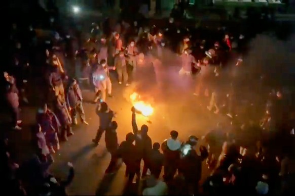 In this frame grab from footage circulating on social media shows protesters dancing and cheering around a bonfire as they take to the streets despite an intensifying crackdown as the Islamic Republic ...
