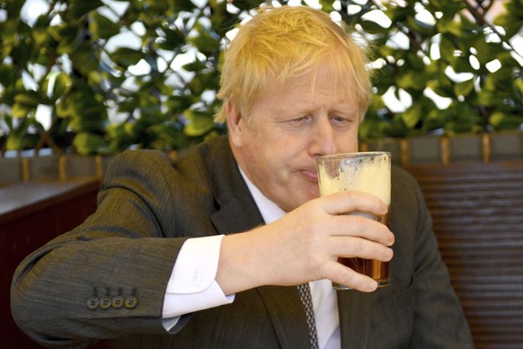 Britain&#039;s Prime Minister Boris Johnson sips a pint in the beer garden of The Mount pub and restaurant in Wolverhampton, central England, Monday April 19, 2021, during the Conservative party elect ...