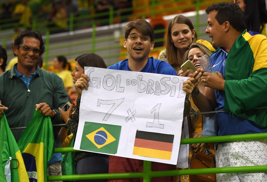 epa05475303 A supporter of Brazil shows a placard referring to the soccer World Cup 2014 semi-final match between Brazil and Germany after the men&#039;s preliminary round match between Brazil and Ger ...