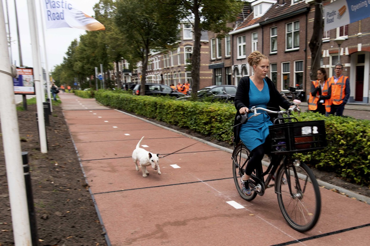 epa07046625 A woman rides a bike on the 'PlasticRoad,' a bicycle lane built from recycled plastic in Zwolle, the Netherlands, 11 September 2018 (issued 25 September 2018). The first in the w ...