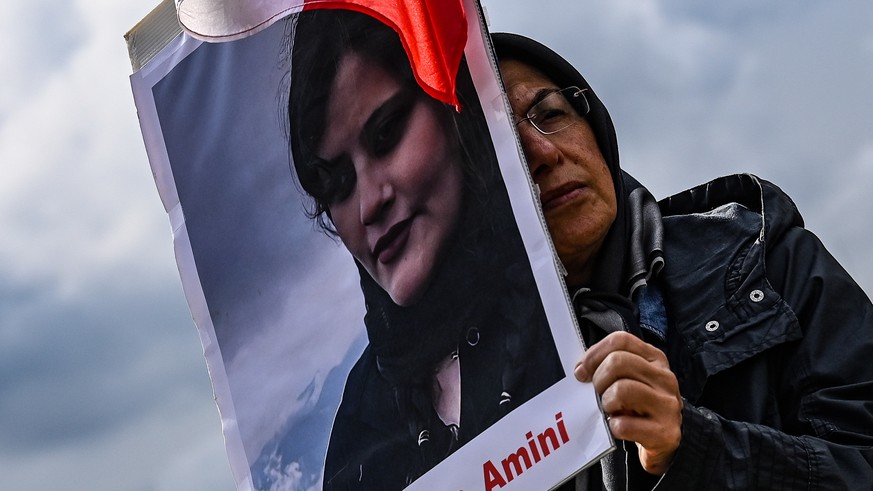 epaselect epa10211352 A participant holds poster of Mahsa Amini during a rally in front of the Reichstag building in Berlin, Germany, 28 September 2022. Iran has been facing many anti-government prote ...