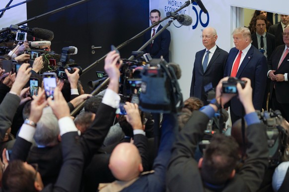 US President Donald Trump, right, addresses to media next to German Klaus Schwab, left, Founder and Executive Chairman of the World Economic Forum, WEF, before addressing a plenary session during to t ...