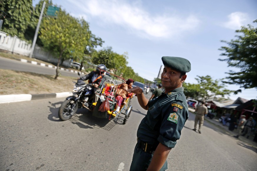 epa06159165 Sharia Police officers stop a motorcyclist for wearing tight trousers during Sharia Police raids in Banda Aceh, Indonesia, 24 August 2017. Women have to wear veils in public areas and are  ...