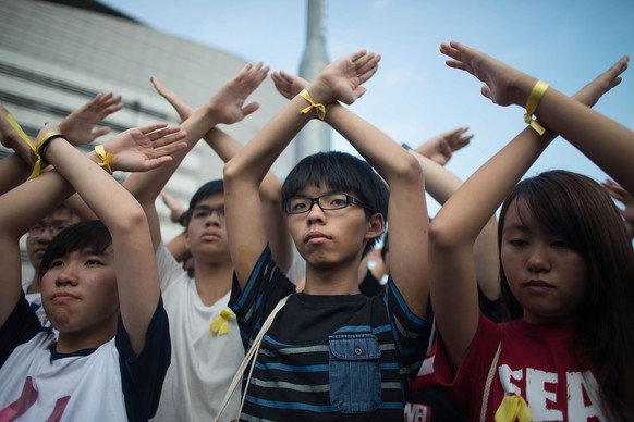 Bei der Flaggen-Zeremonie: Studentenführer Joshua Wong und seine Mitstreiter kreuzen demonstrativ die Hände.